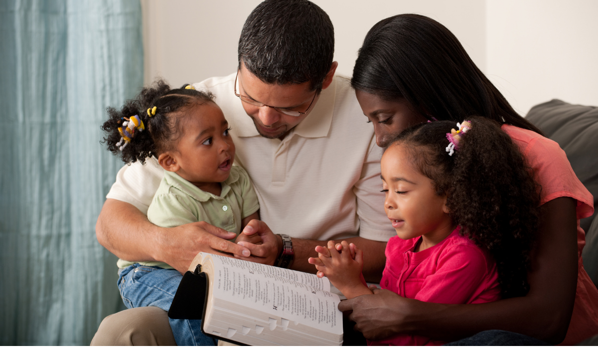 family praying and reading the bible